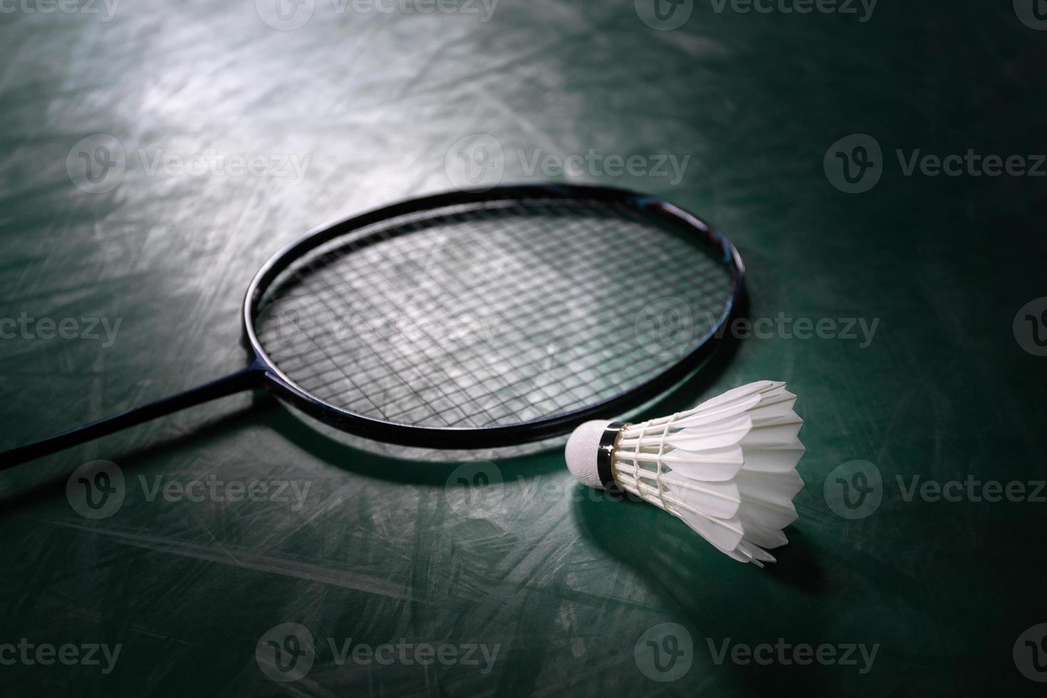 Badmintonbal of shuttlehaan met badmintonracket in de rechtbank met professionele badmintonspeler spelen in de rechtbank in de sportschool voor gezonde en sportkampioenschappen foto