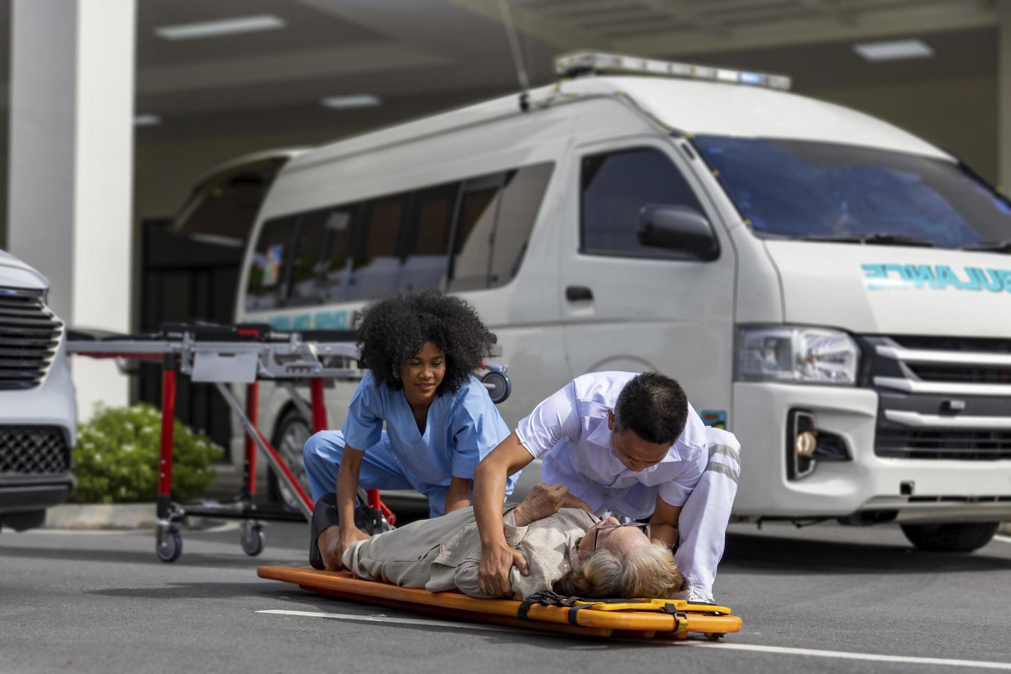 team van paramedicus helpt de senior patiënt van auto-ongeluk door ruggengraat te gebruiken om over te stappen naar de ambulance voor eerste hulp en straatongevalconcept foto