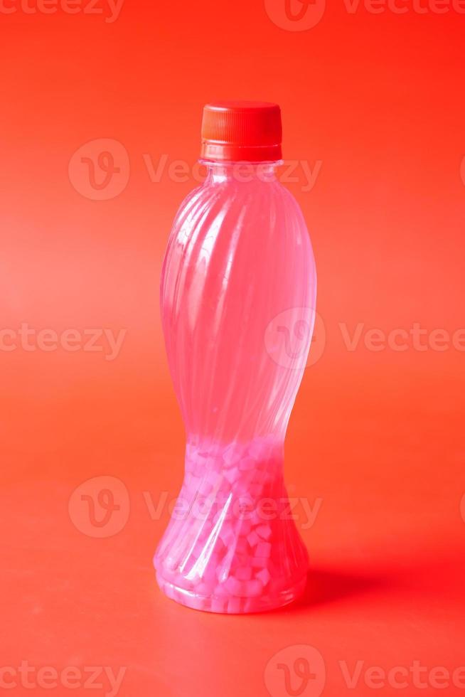 plastic flessen frisdrank op rode achtergrond foto