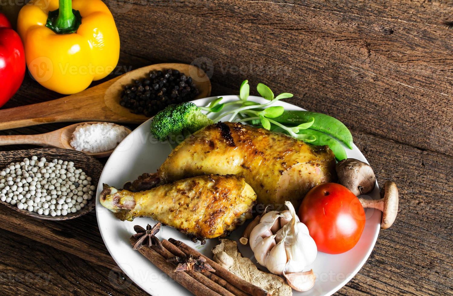 geroosterde kip met ingrediënten op houten tafel. foto