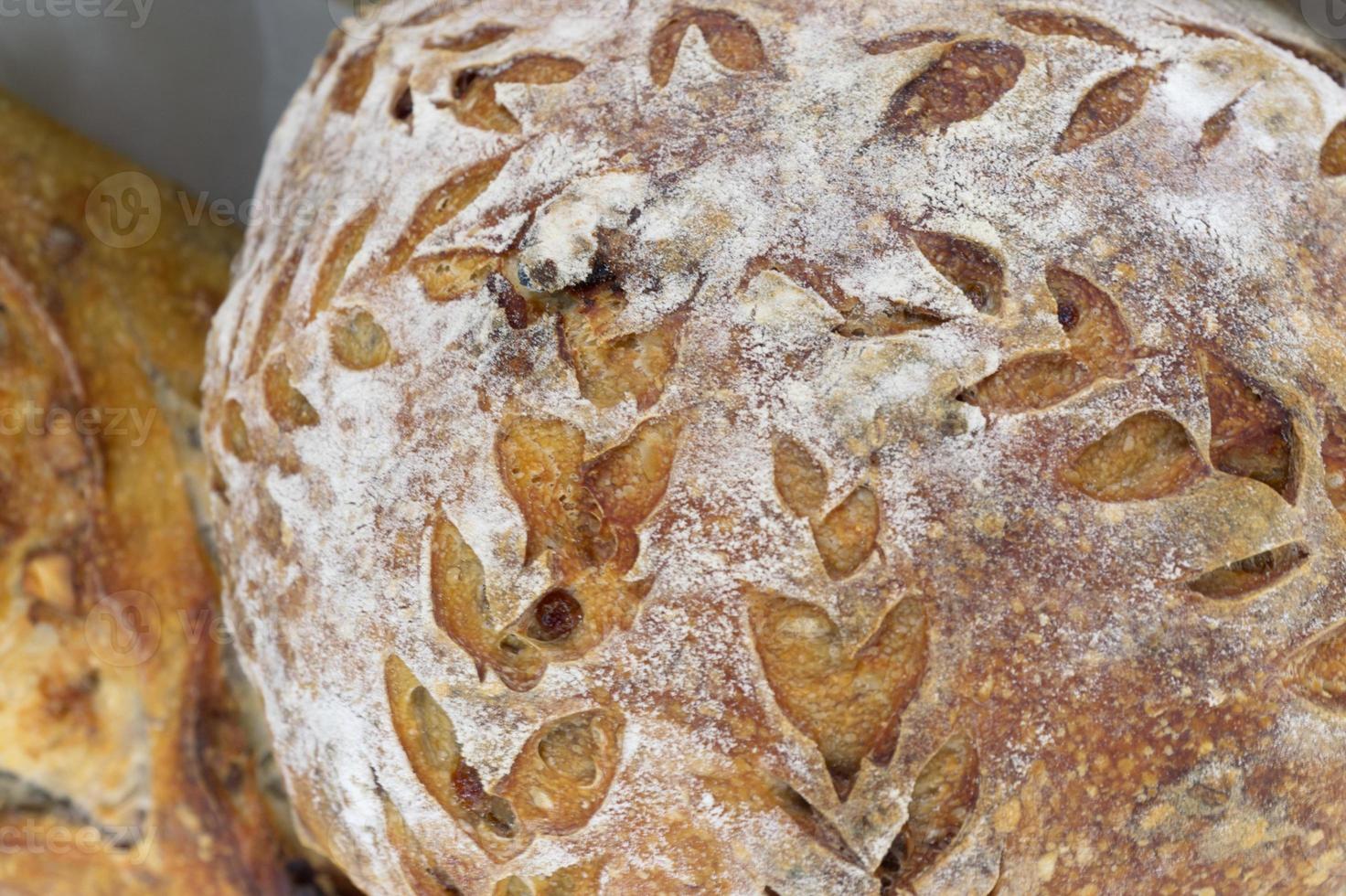 brood van dichtbij. vers gebakken zuurdesembrood met een goudbruin korstje. concept bakkerij, textuur zuurdesembrood foto
