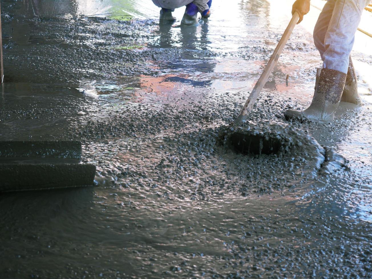 de stukadoor maakt de cementvloer schoon om glad te zijn. foto