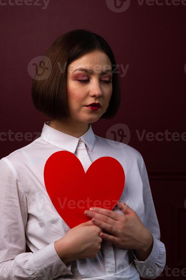dromerige kortharige vrouw met hartvorm voor haar borst foto