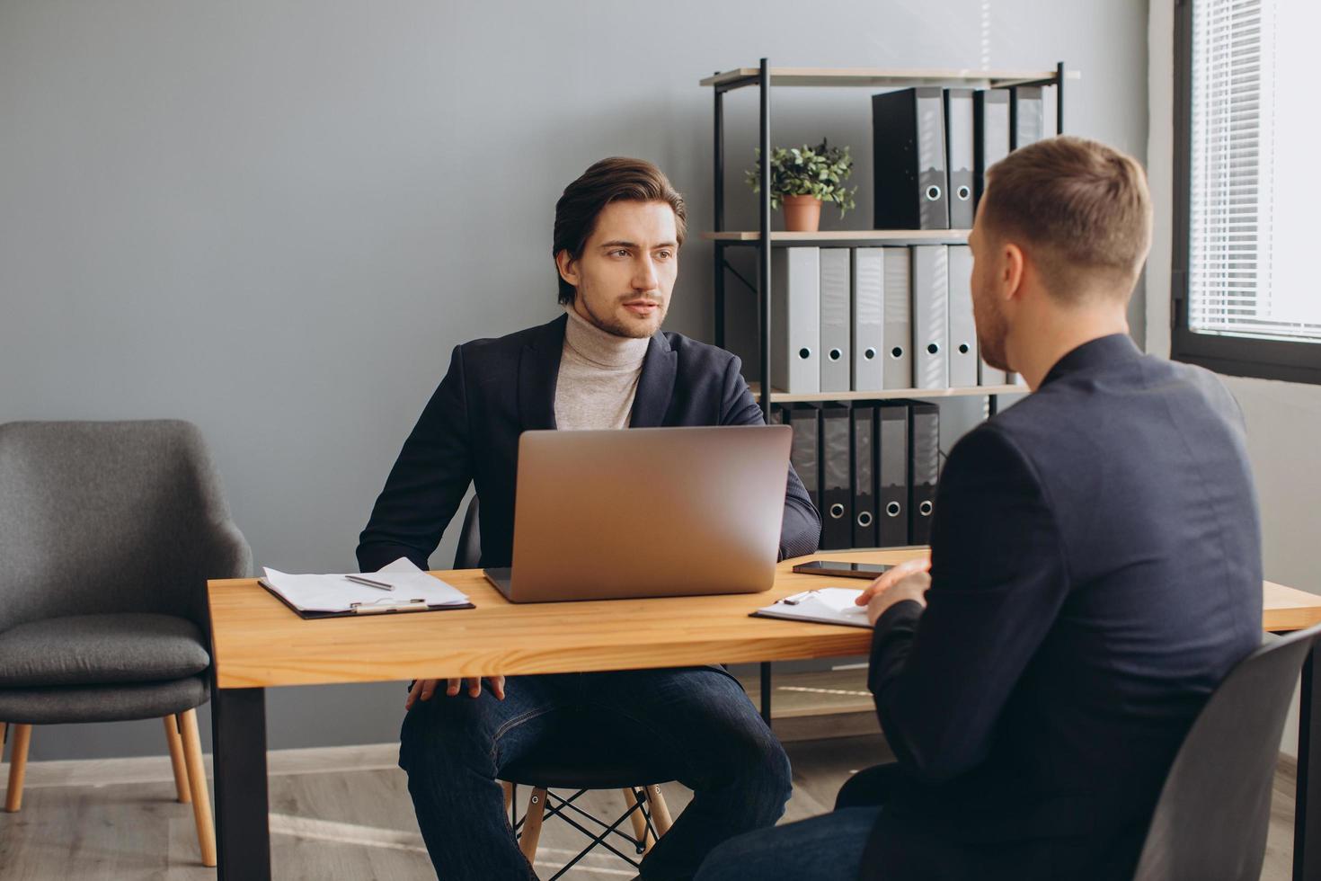 een man houdt een zakelijke bijeenkomst en tekent een contract, arbeidsovereenkomst of overeenkomst. foto