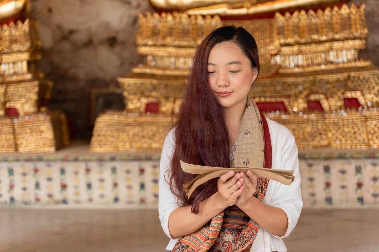 portret jonge aziatische vrouw die traditionele kleding van thailand draagt lezing sanskriet oude tripitaka boek van heer boeddha dhamma foto