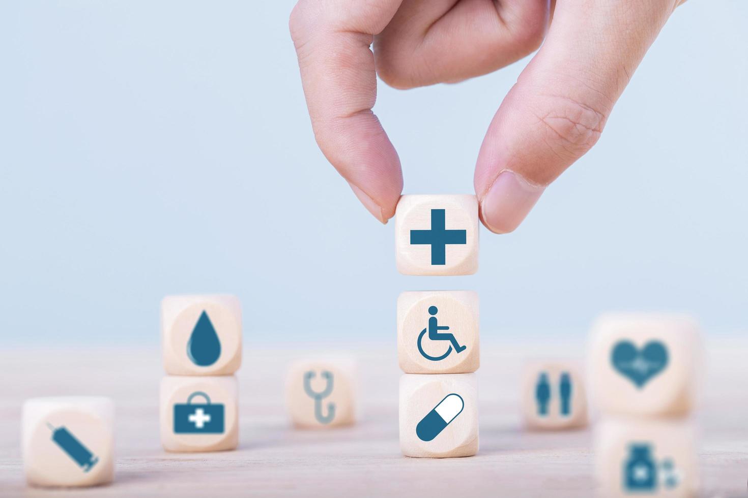 hand kiest een emoticon pictogrammen gezondheidszorg medisch symbool op houten blok, gezondheidszorg en medische verzekering concept foto