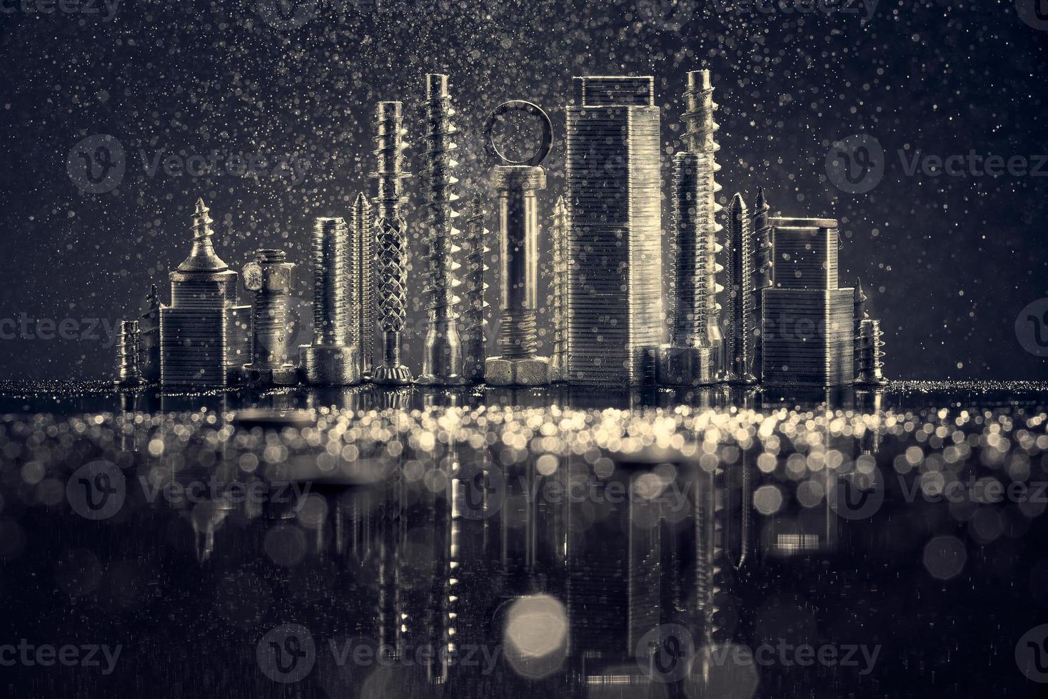 abstract panorama van de stad verlicht door fel licht met reflectie, gemaakt door metalen bout en moer chroom. zwarte achtergrond met bokeh. foto