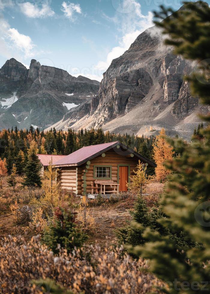 houten hutten met rotsachtige bergen in het herfstbos in het provinciale park van Assiniboine foto