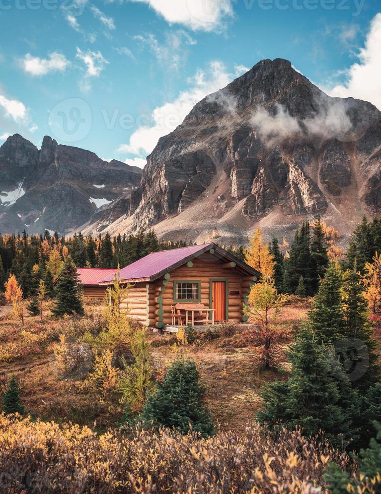 houten hut met rotsachtige bergen in de herfstbos op nationaal park foto