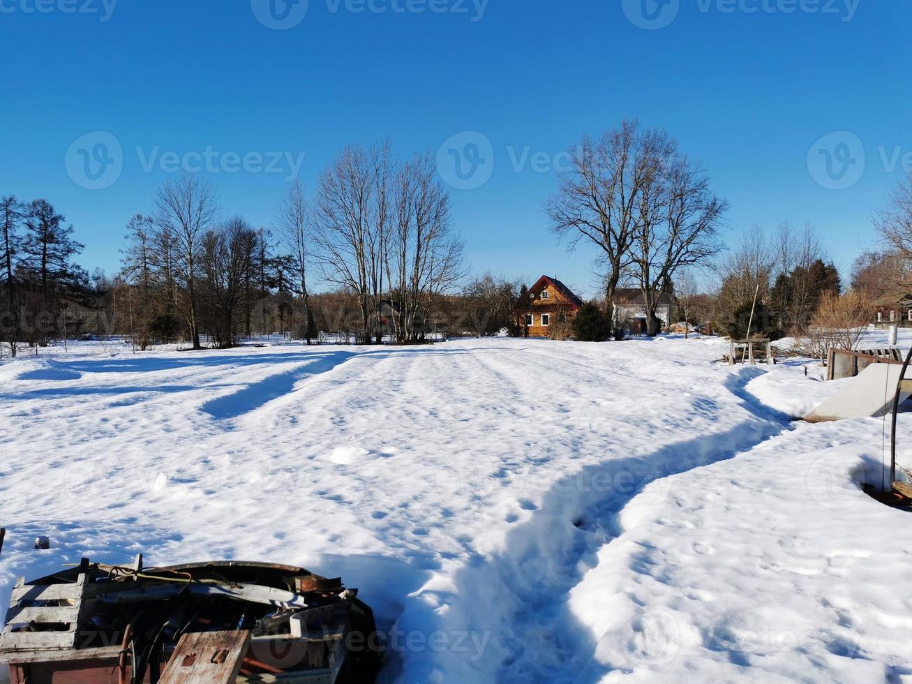 lentedag in het Russische dorp sneeuwput blauwe lucht foto