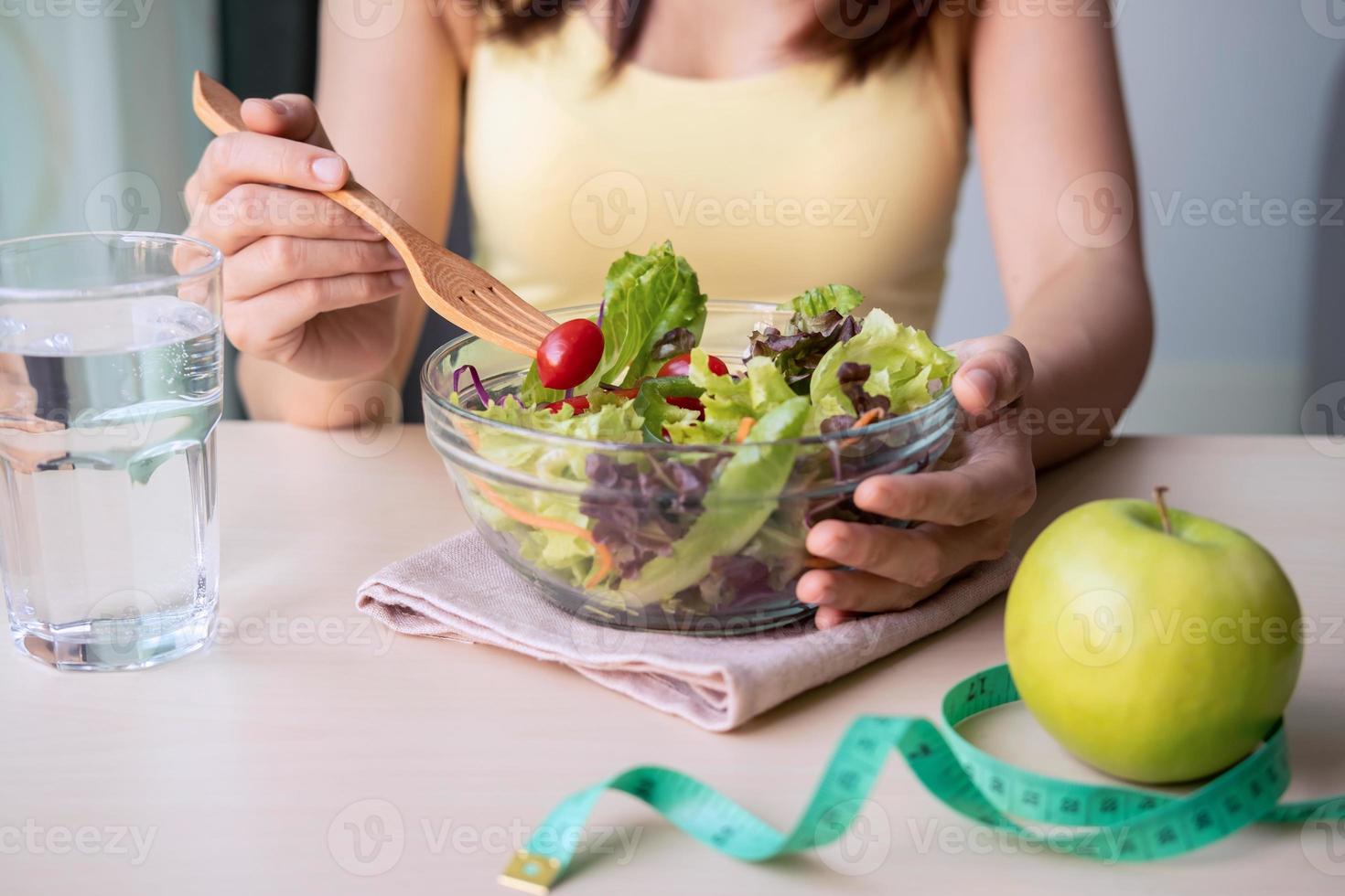 jonge vrouw die zelfgemaakte gezonde salade thuis eet, gezonde levensstijl, dieetconcept foto