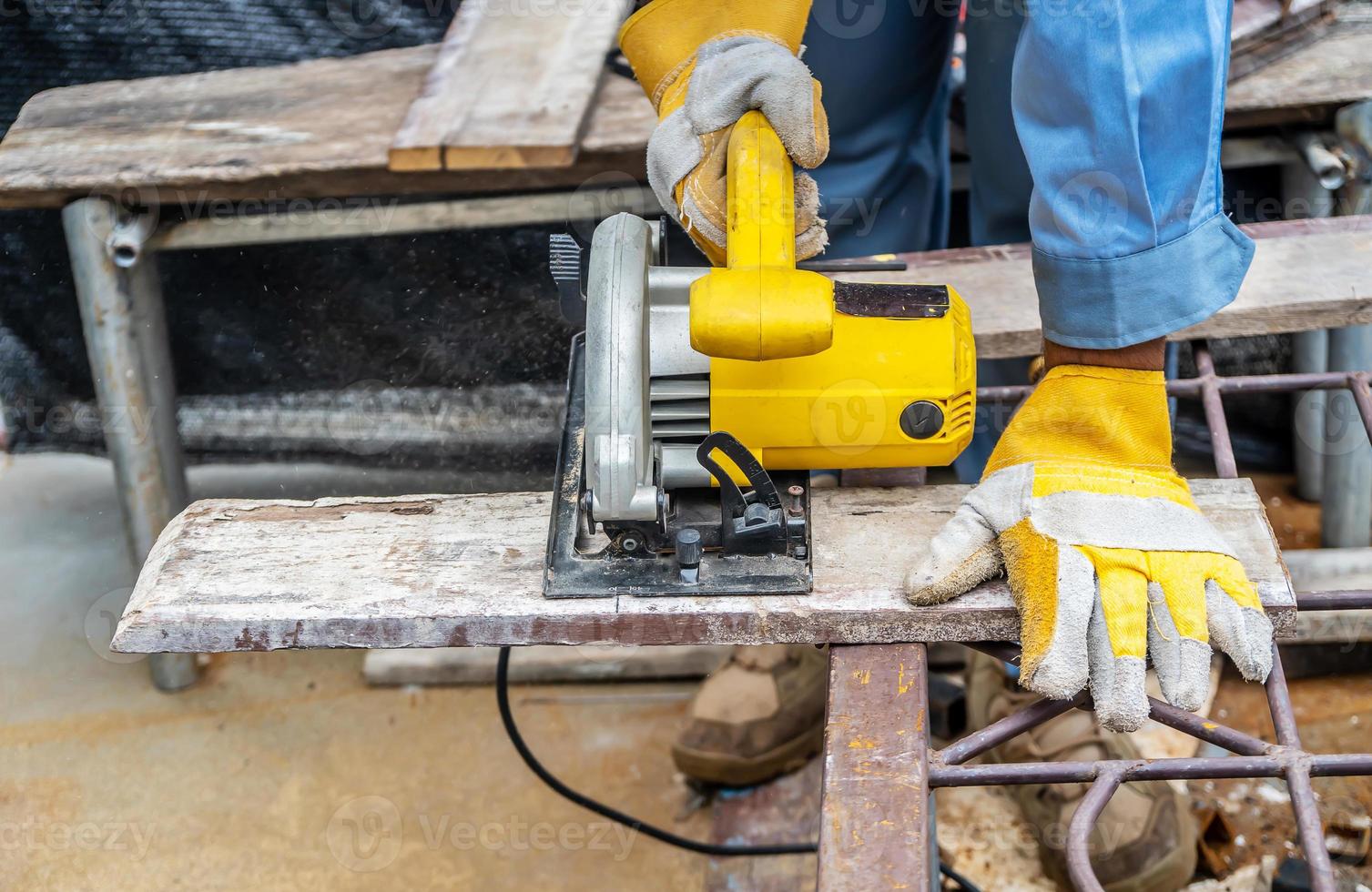 timmerman die cirkelzaag gebruikt voor het snijden van houten planken met elektrisch gereedschap, bouw- en woningrenovatie, reparatie en constructiegereedschap foto