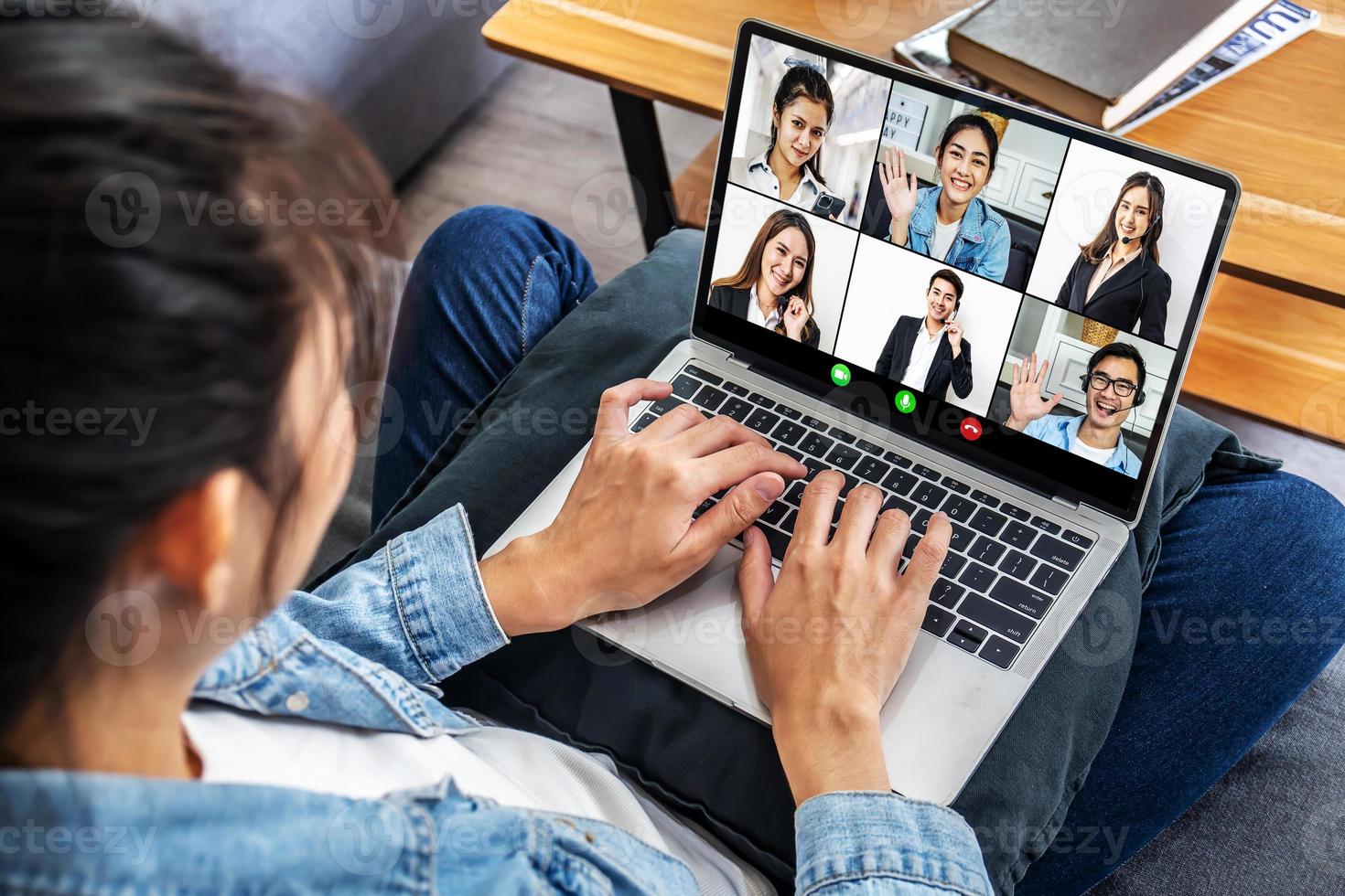 business team werkt vanuit huis in een videoconferentie. het achteraanzicht van een meisje dat online via videoconferentie communiceert met haar collega's die thuis een laptop gebruiken foto