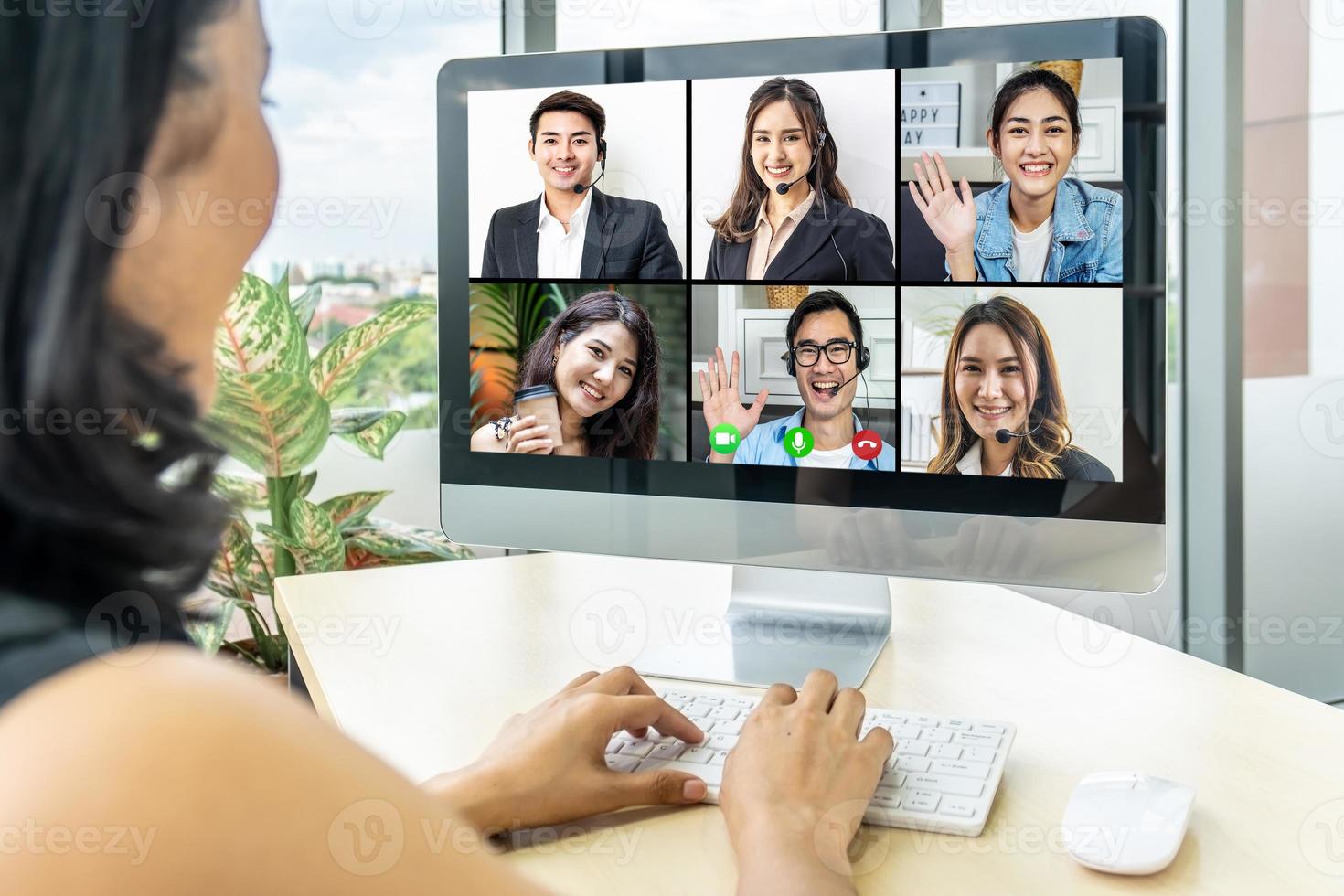 zakenvrouw zit aan het bureau en kijkt naar het computerscherm waar de collage van verschillende mensen de webcam bekijkt. aziatische vrouw leidt videogesprek op afstand chat, groep verschillende vrienden met behulp van videoconferentie foto