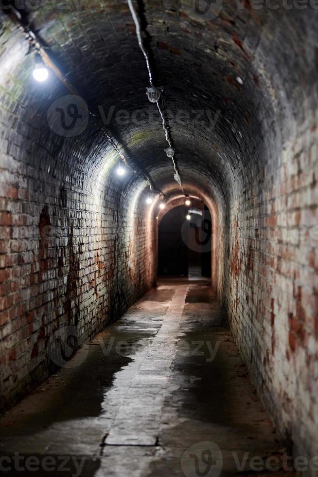 zolderbakstenen tunnel in oud Duits fort, geheime doorgang met oude elektriciteitsbedrading, kaliningrad foto