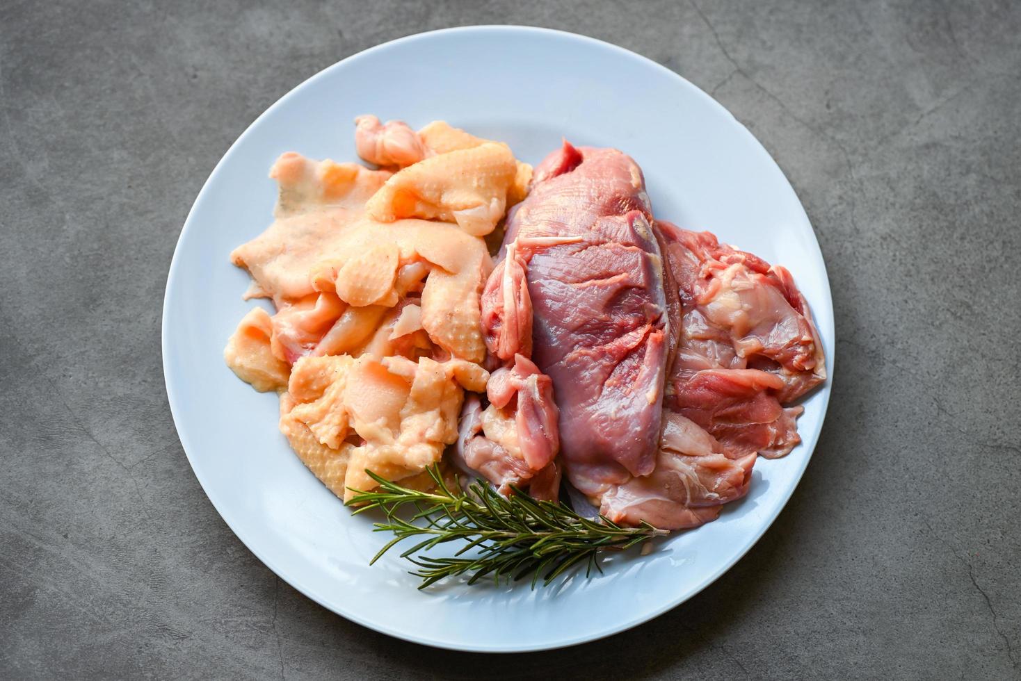 rauwe eendenborst en eendenhuid met kruidenrozemarijn om op het bord te koken, vers eendenvlees als voedsel foto