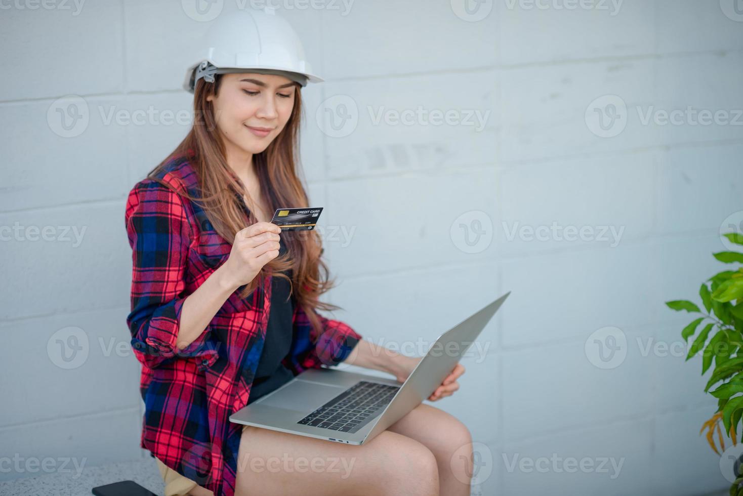 vrouwelijke bouwingenieur kijkt naar creditcards foto