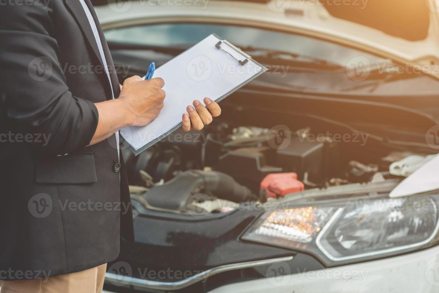 de monteur die de auto onderhoudt, registreert de resultaten van de auto-inspectie. foto