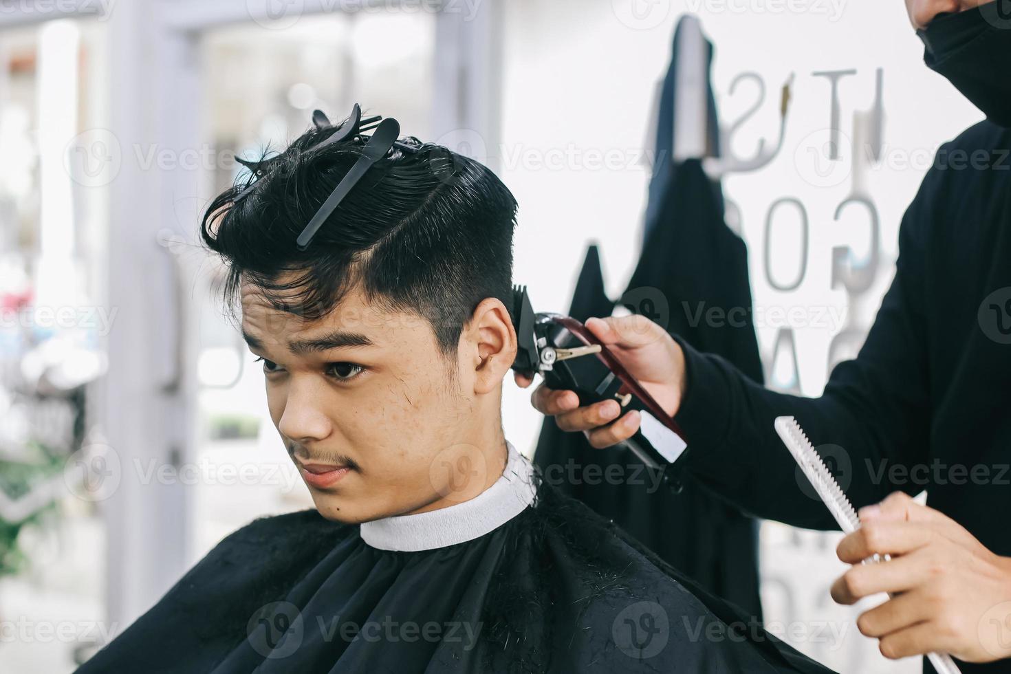 kapper scheert het haar van de consument met tondeuse foto