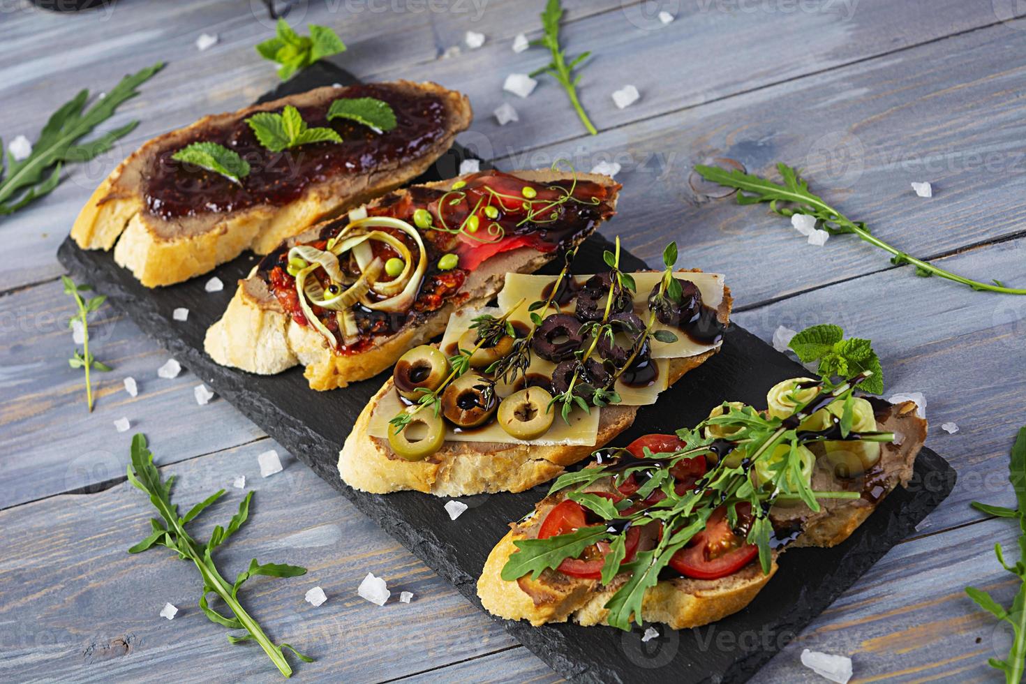 bruschetta met kippenleverpasta. heerlijke bruschetta's met verschillende vullingen. verschillende bruschetta ob houten achtergrond foto