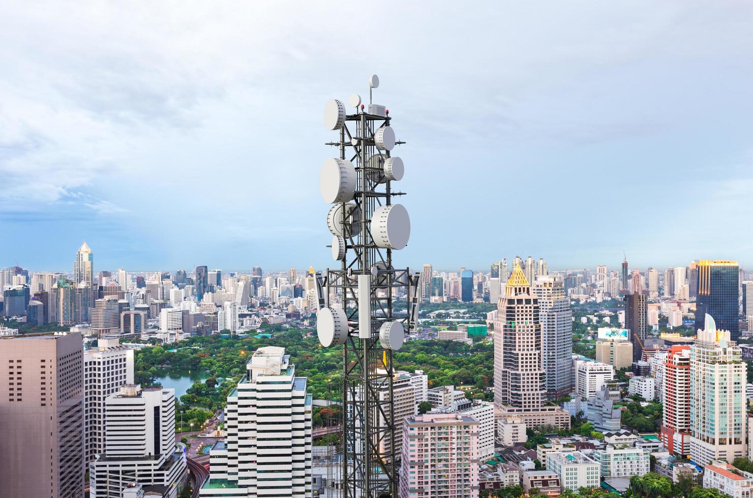 telecommunicatietoren met 5g cellulaire netwerkantenne op stadsachtergrond foto