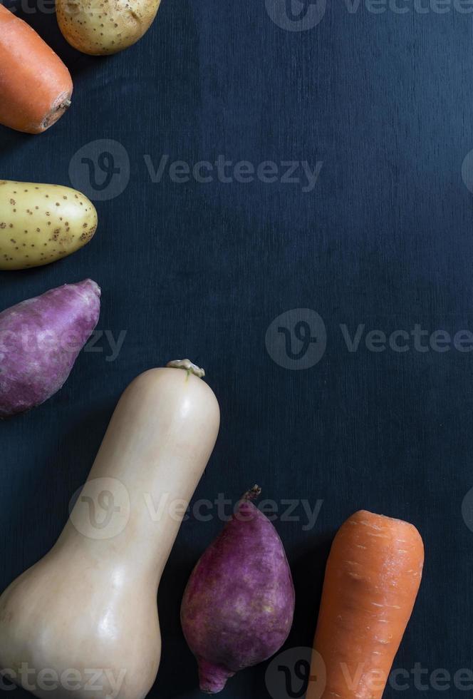 gezonde voeding butternut squash wortel zoete aardappel geïsoleerd op zwarte houten achtergrond heeft kopie ruimte. foto