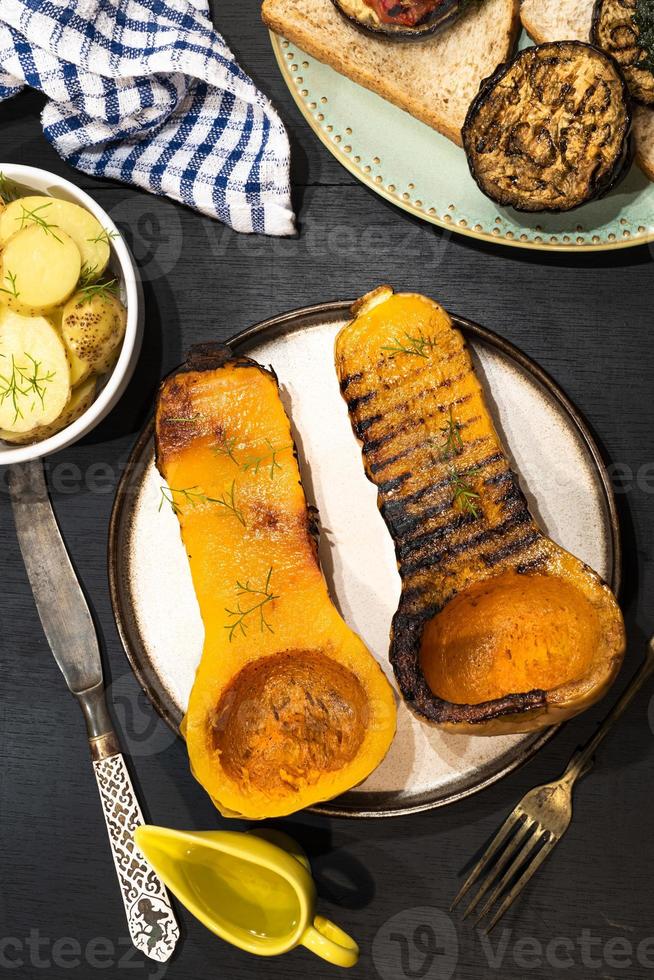 gezonde voeding geroosterde pompoen op zwarte houten tafel. foto