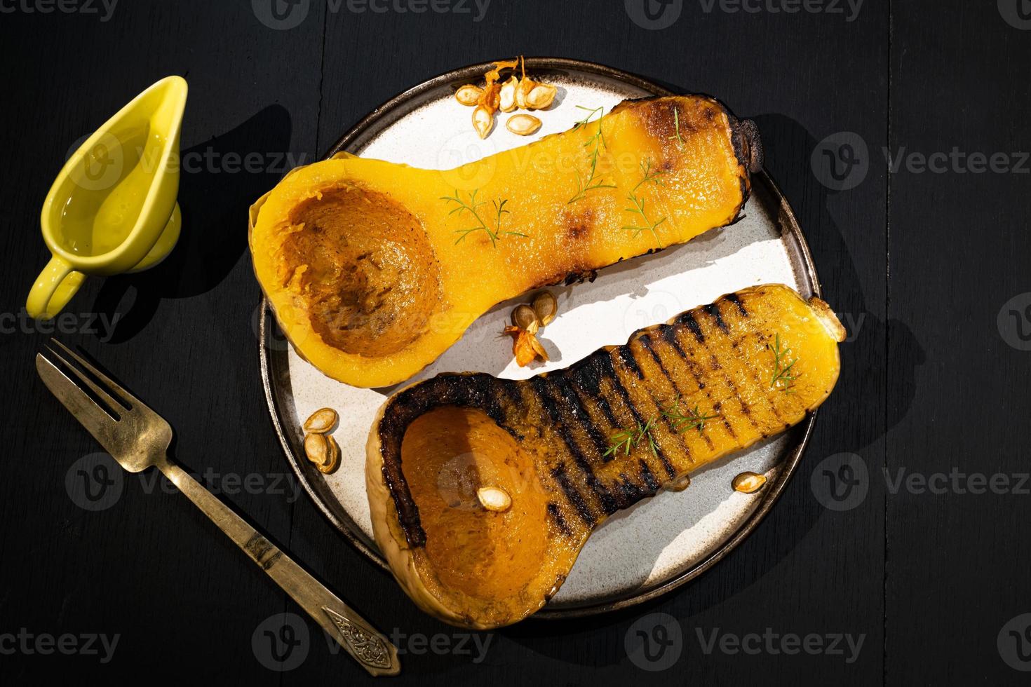 gezonde voeding geroosterde pompoen op zwarte houten tafel. foto