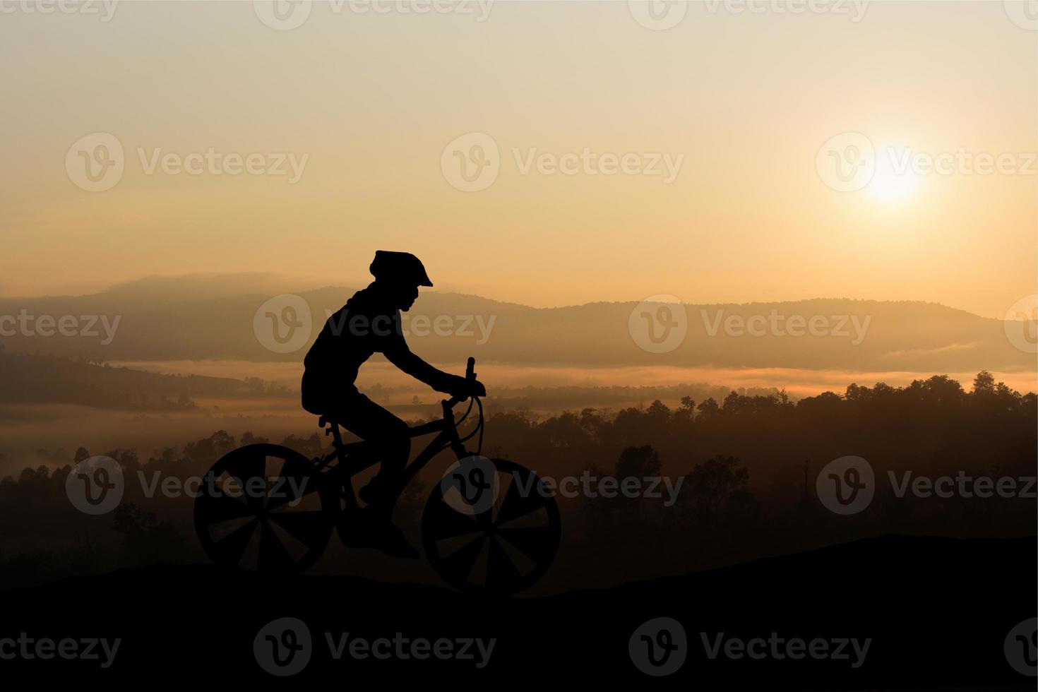 silhouetten man en fiets op de berg in het zonlicht foto