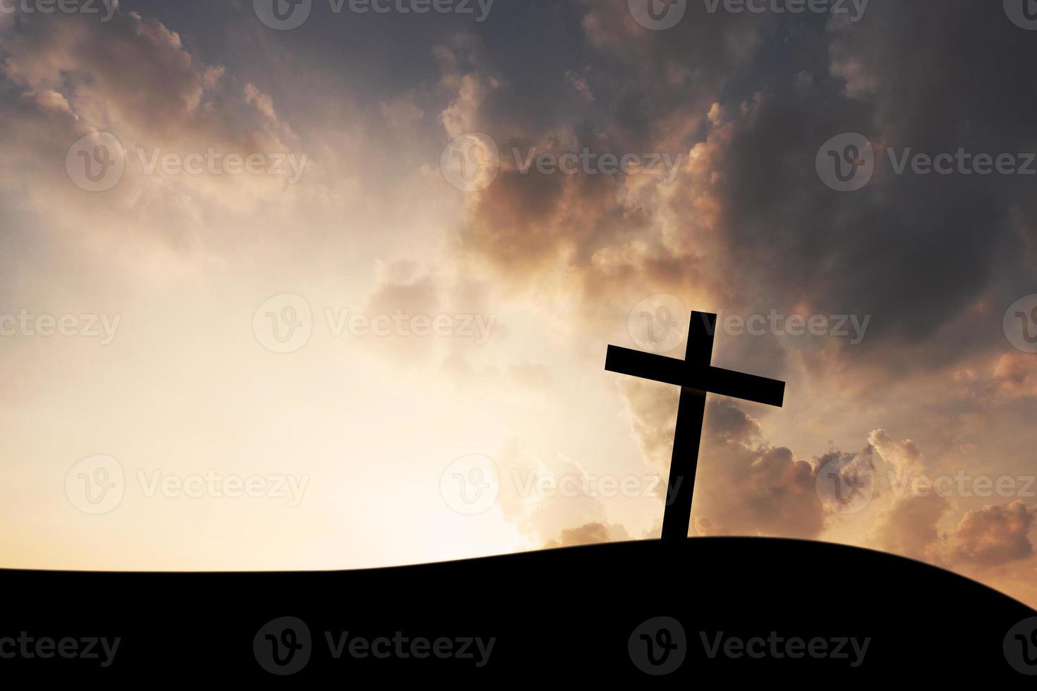het kruis op de achtergrond van de bergzonsondergang foto