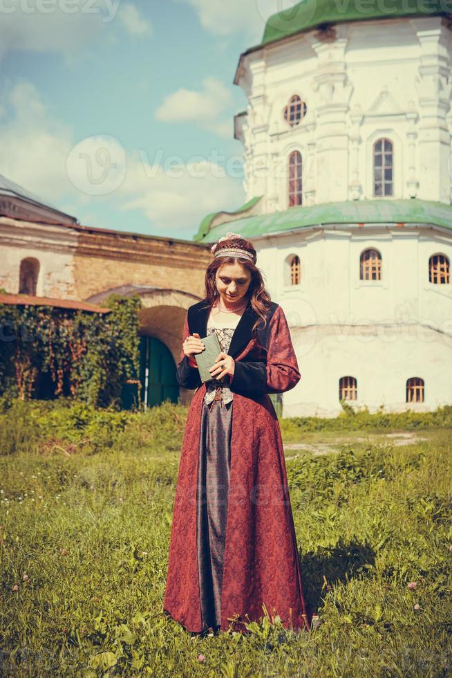 portret van brunette vrouw gekleed in historische barokke kleding met ouderwets kapsel, buitenshuis. foto