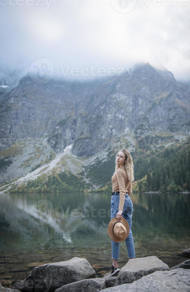 jonge vrouw die op meer in bos reist. foto