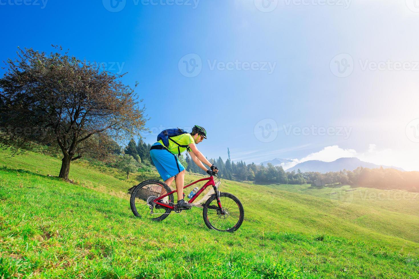een jonge man die bergafwaarts rijdt op een mountainbike foto