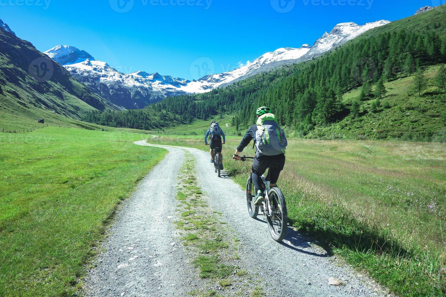 paar vrienden fietsers met mountainbikes in de bergen in een prachtig landschap op de alpen foto