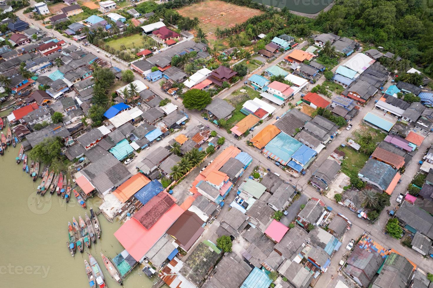 luchtfoto bovenaanzicht van het vissersdorp met vissersboten en huisdak op de pier in suratthani thailand. hoge kijkhoek foto