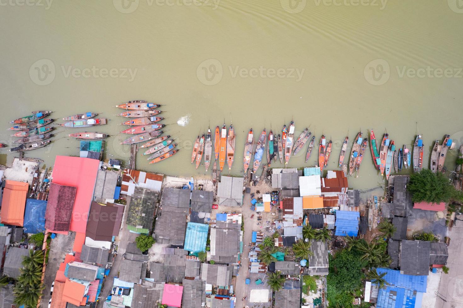 luchtfoto bovenaanzicht van het vissersdorp met vissersboten en huisdak op de pier in suratthani thailand. hoge kijkhoek foto