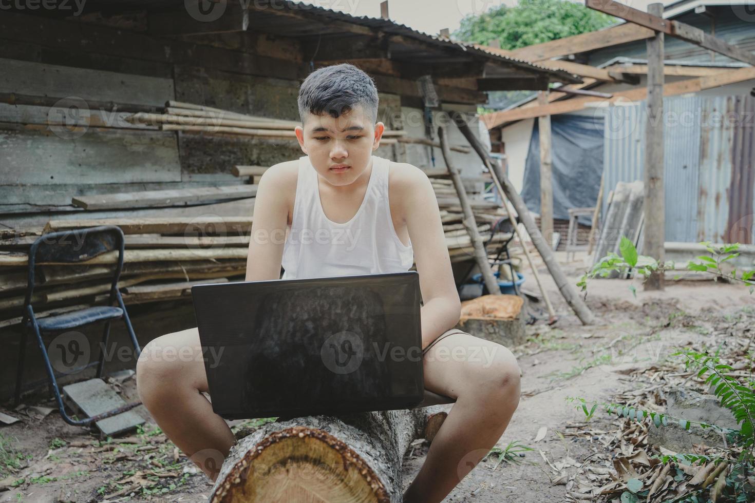 jongens studeren door online te leren met laptop op outdoor.poverty creëert ongelijkheid in het onderwijs. foto