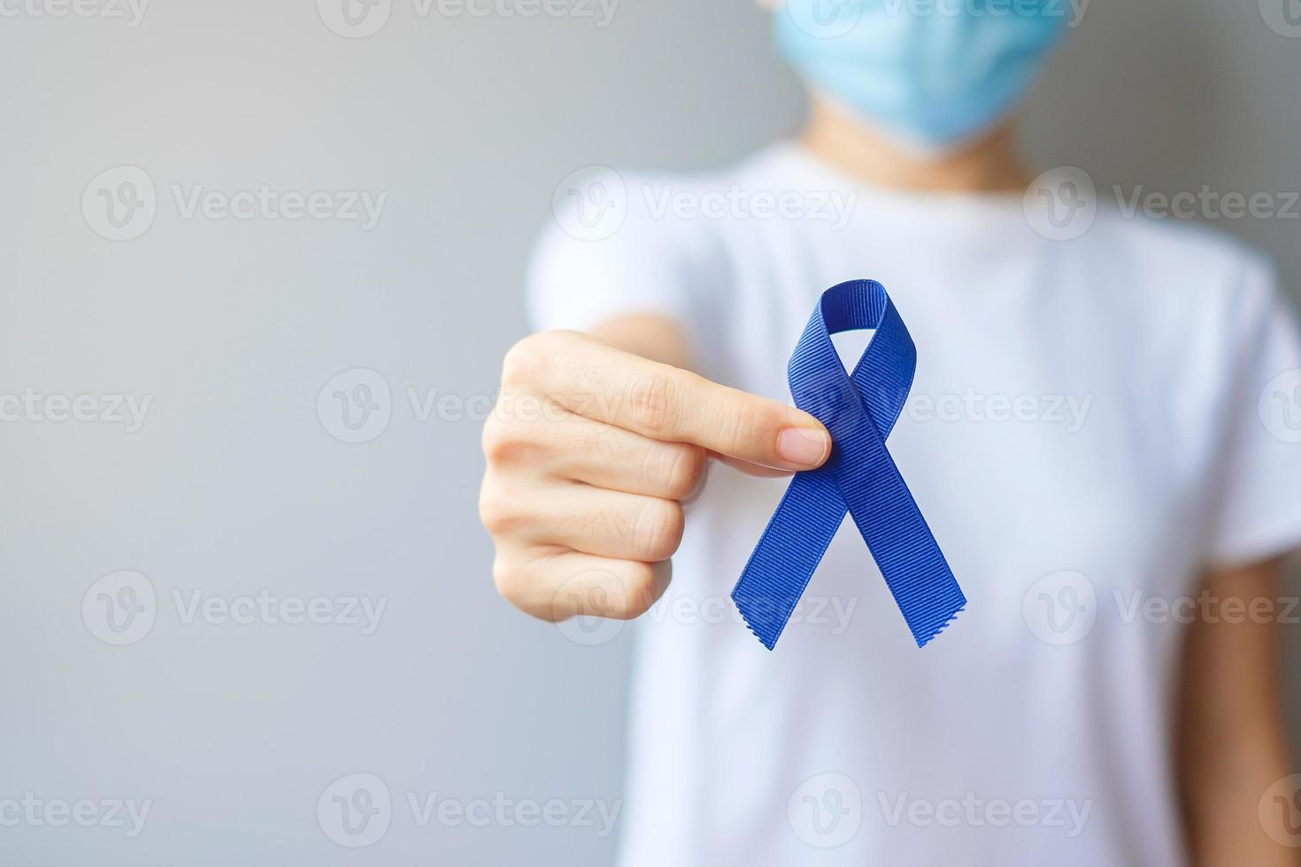 maart colorectale kanker bewustzijn maand, vrouw met donkerblauw lint voor het ondersteunen van mensen die leven en ziekte. gezondheidszorg, hoop en wereldkankerdagconcept foto