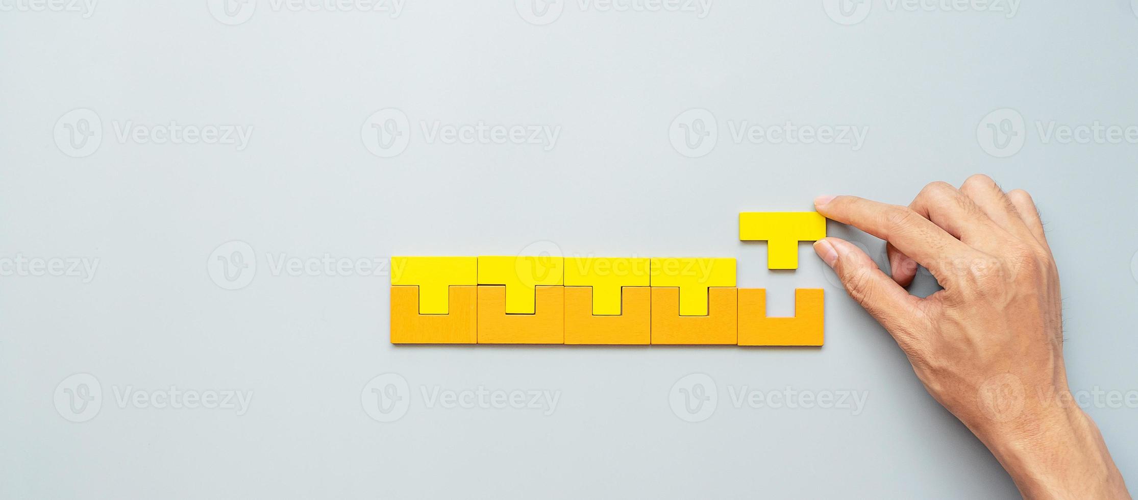 hand verbindend geometrische vormblok met kleurrijke houten puzzelstukjes. logisch denken, bedrijfslogica, raadsel, beslissing, oplossingen, rationeel, missie, succes, doelen en strategieconcepten foto