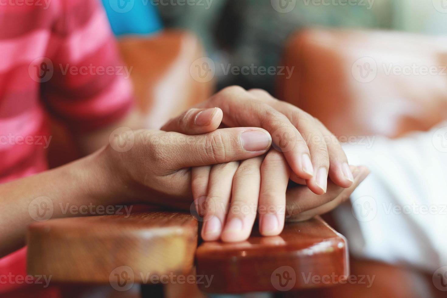 ouderling houdt jonge handen vast foto