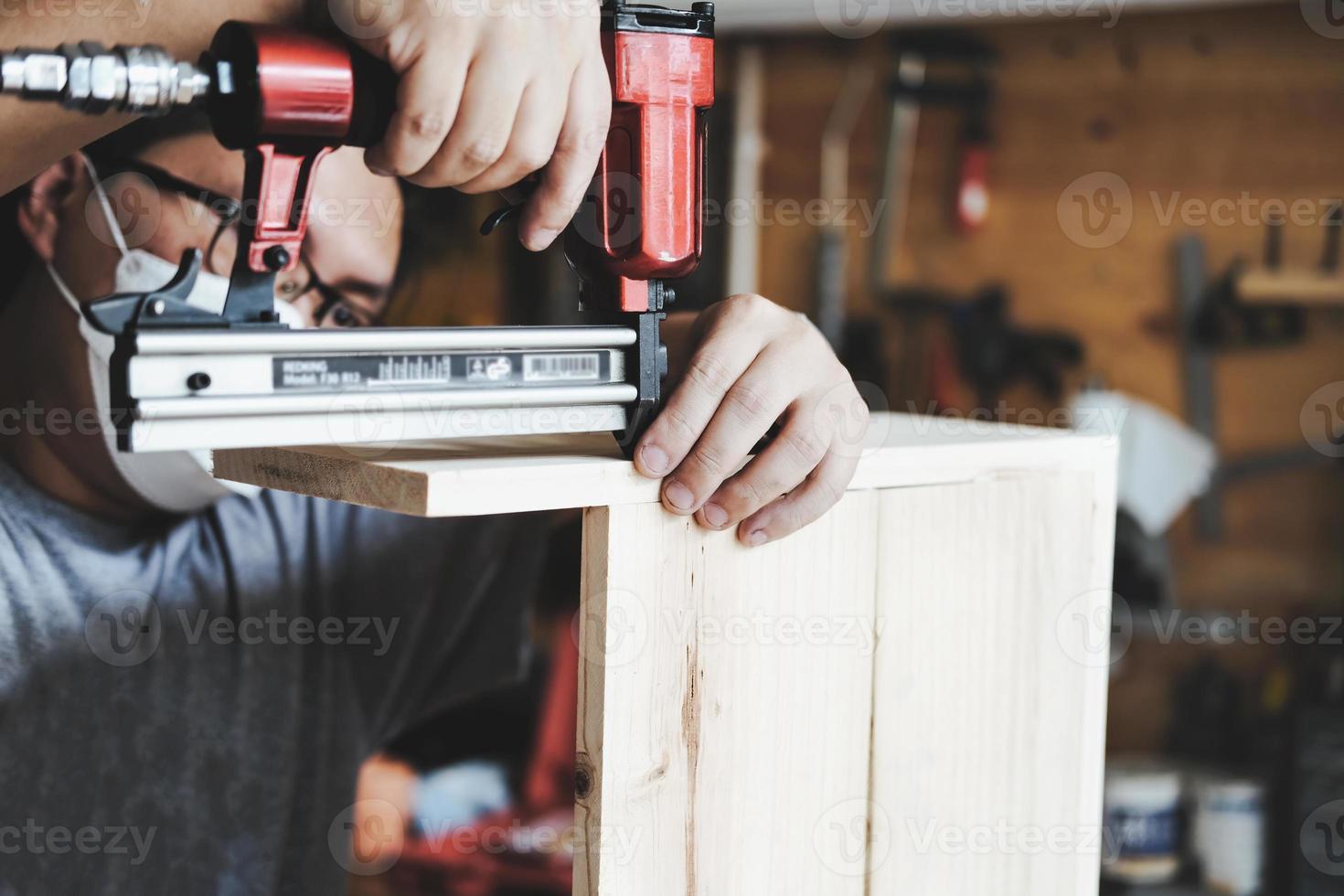 ondernemer houtwerk met een tacker om de stukken hout te monteren zoals de klant besteld. foto