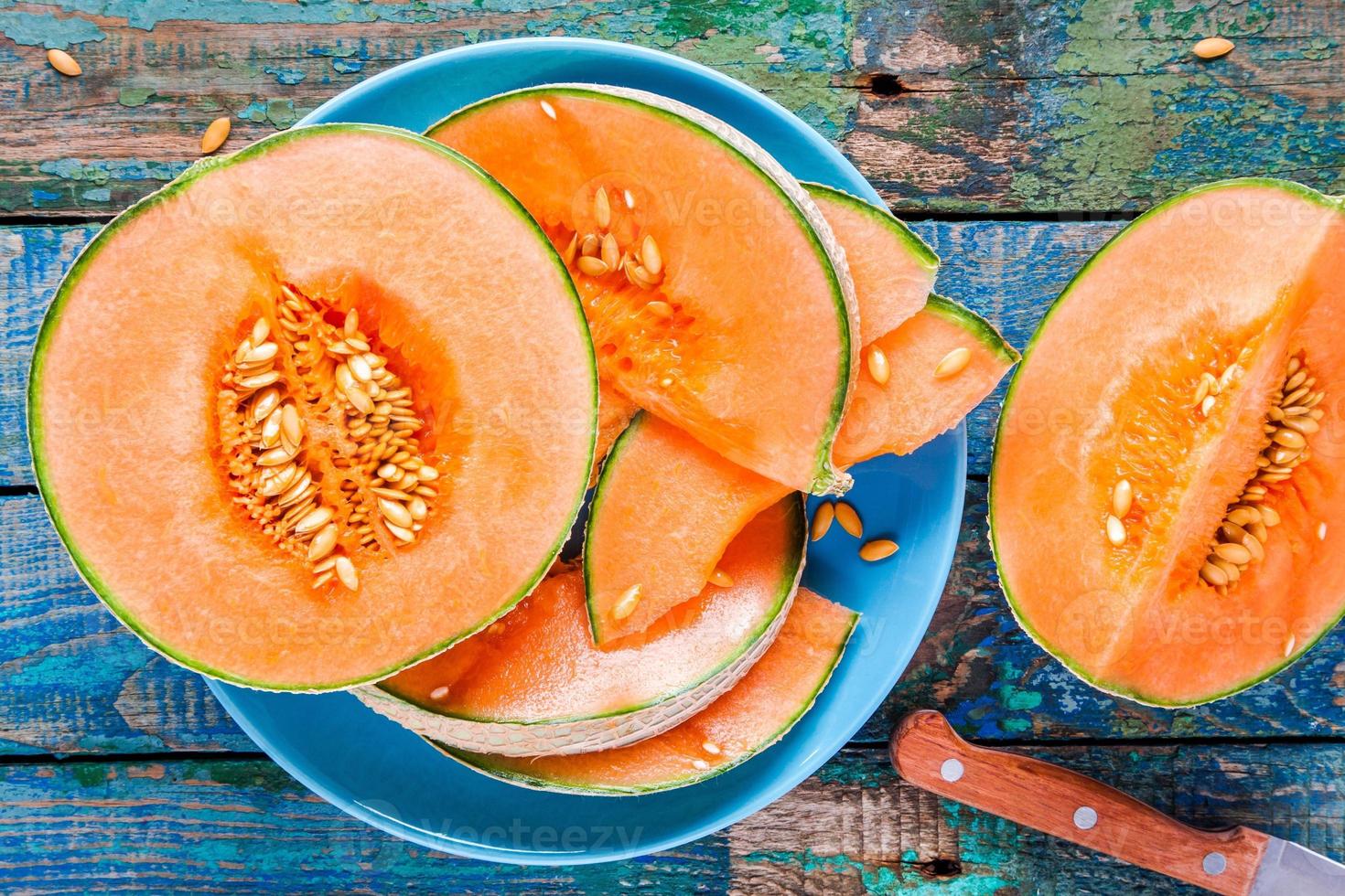 gesneden rijpe meloen op een plaat op een rustieke achtergrond foto