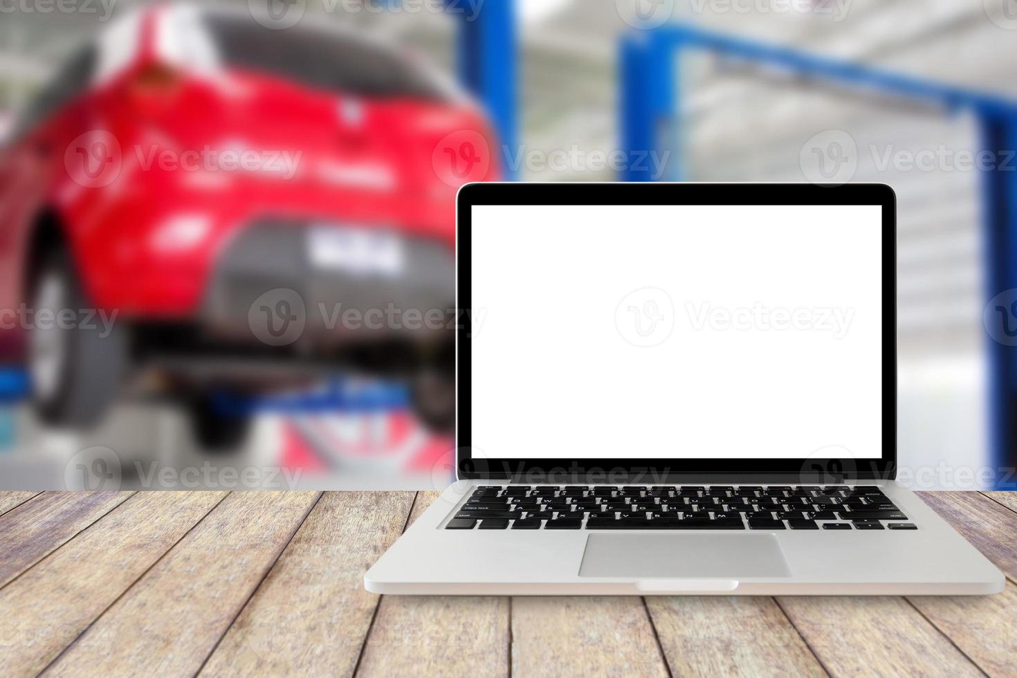 laptop op houten tafel met een wazige achtergrond van het autoservicecentrum foto