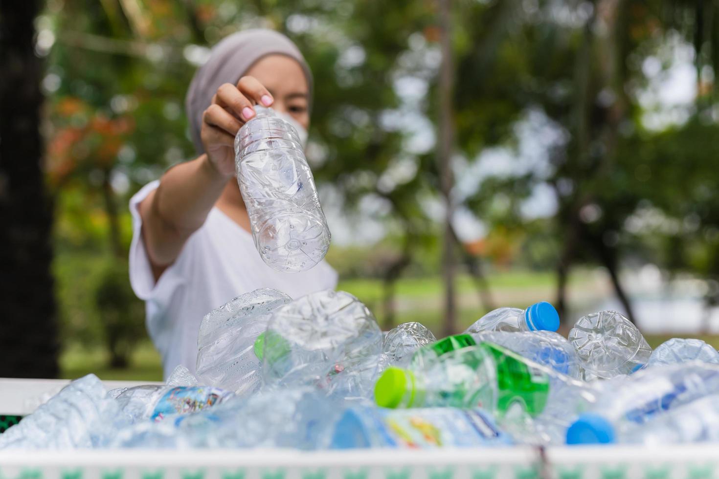 vrouw hand met recycle plastic fles in vuilnisbak conceptuele omgeving. foto