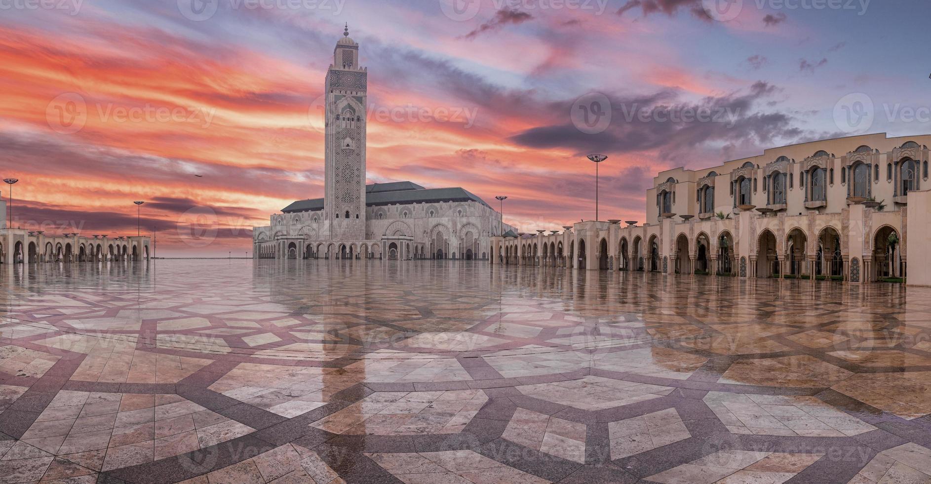 lage hoekmening van historische moskee hasan ii met de hoogste minaret tegen dramatische hemel foto