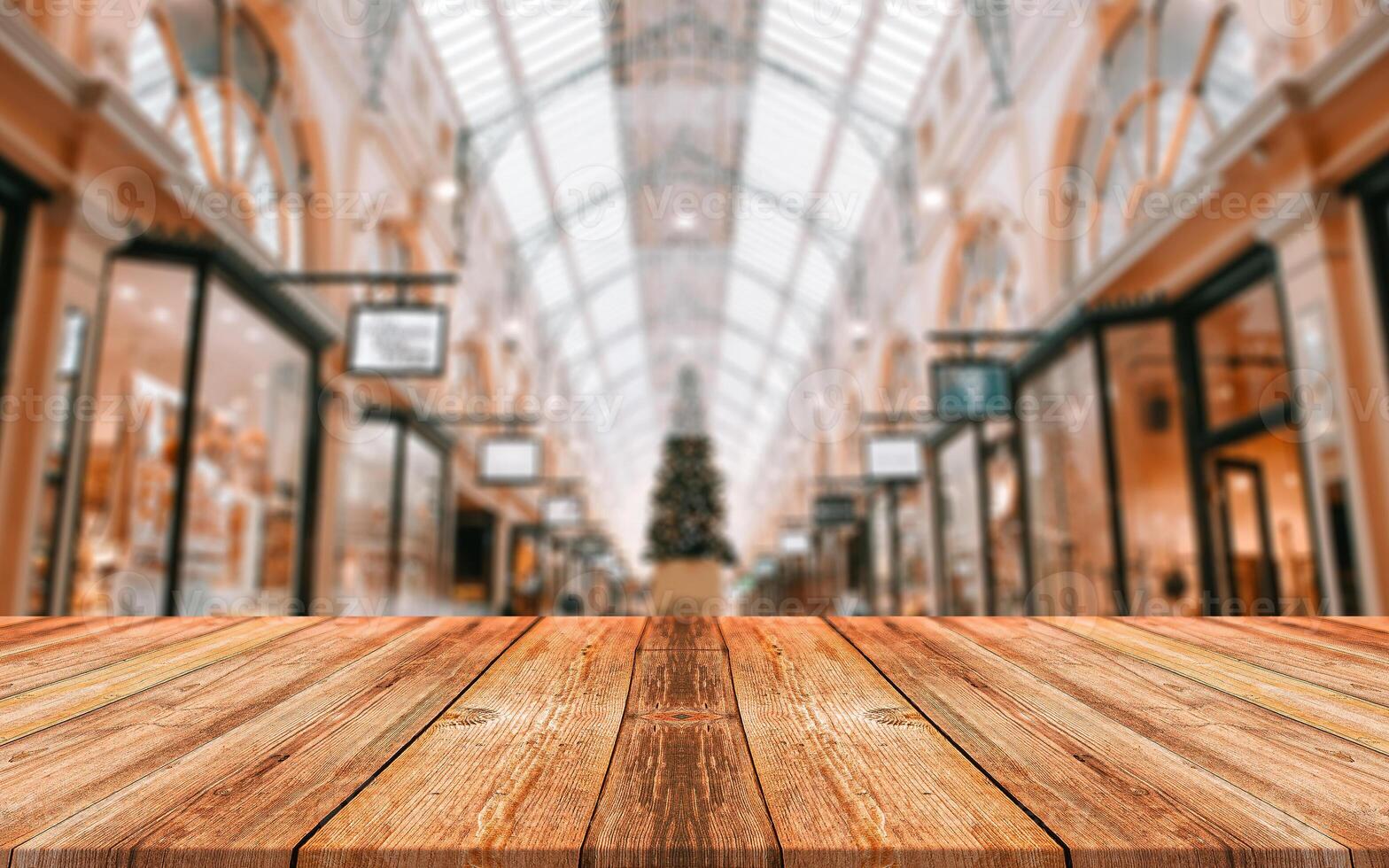 lege houten tafel voor abstracte onscherpe achtergrond van winkelcentrum. houten tafel aan de voorkant kan worden gebruikt voor het weergeven of monteren van uw producten. mock-up voor weergave van het product foto