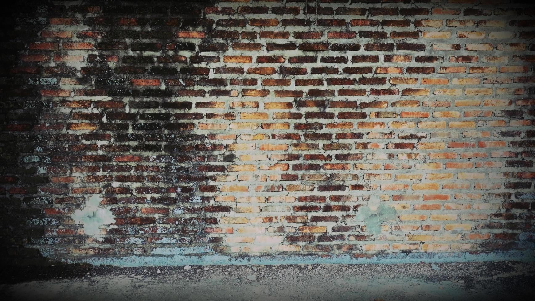 oude bakstenen muur heeft bruine vlekken en krassen. verlaten architectuur is iets verschrikkelijks. foto