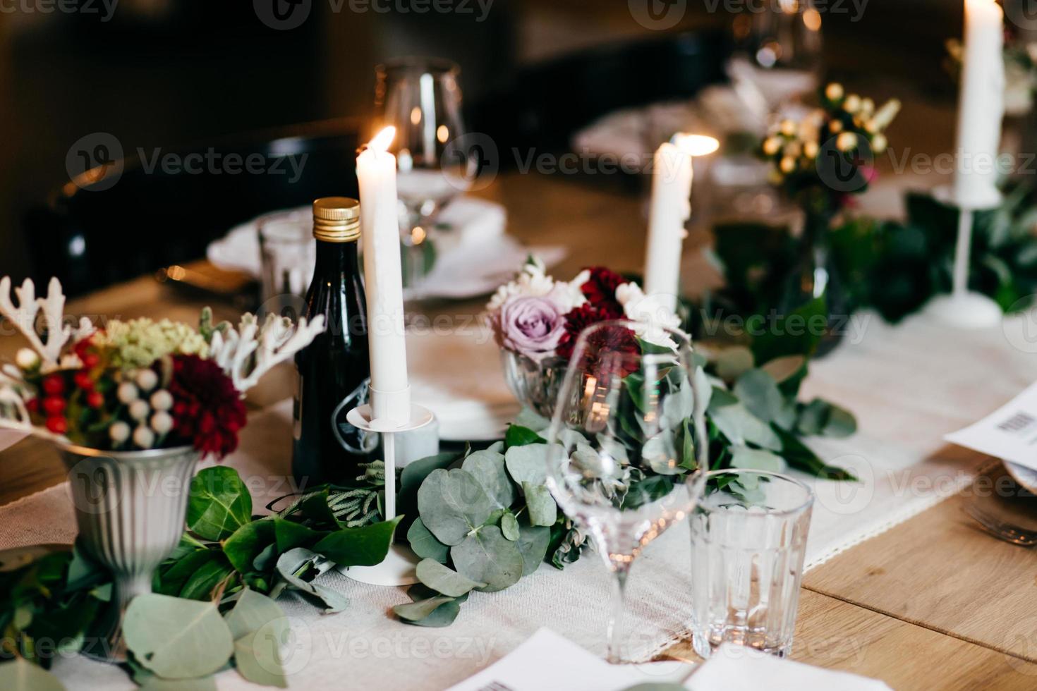 tafel geserveerd voor huwelijksfeest. kaarsen, decoratie, bestek en drankjes op feestelijke tafel. bruiloft tafel versierd met bloemen en kaarsen. tafelsetting, selectieve focus foto