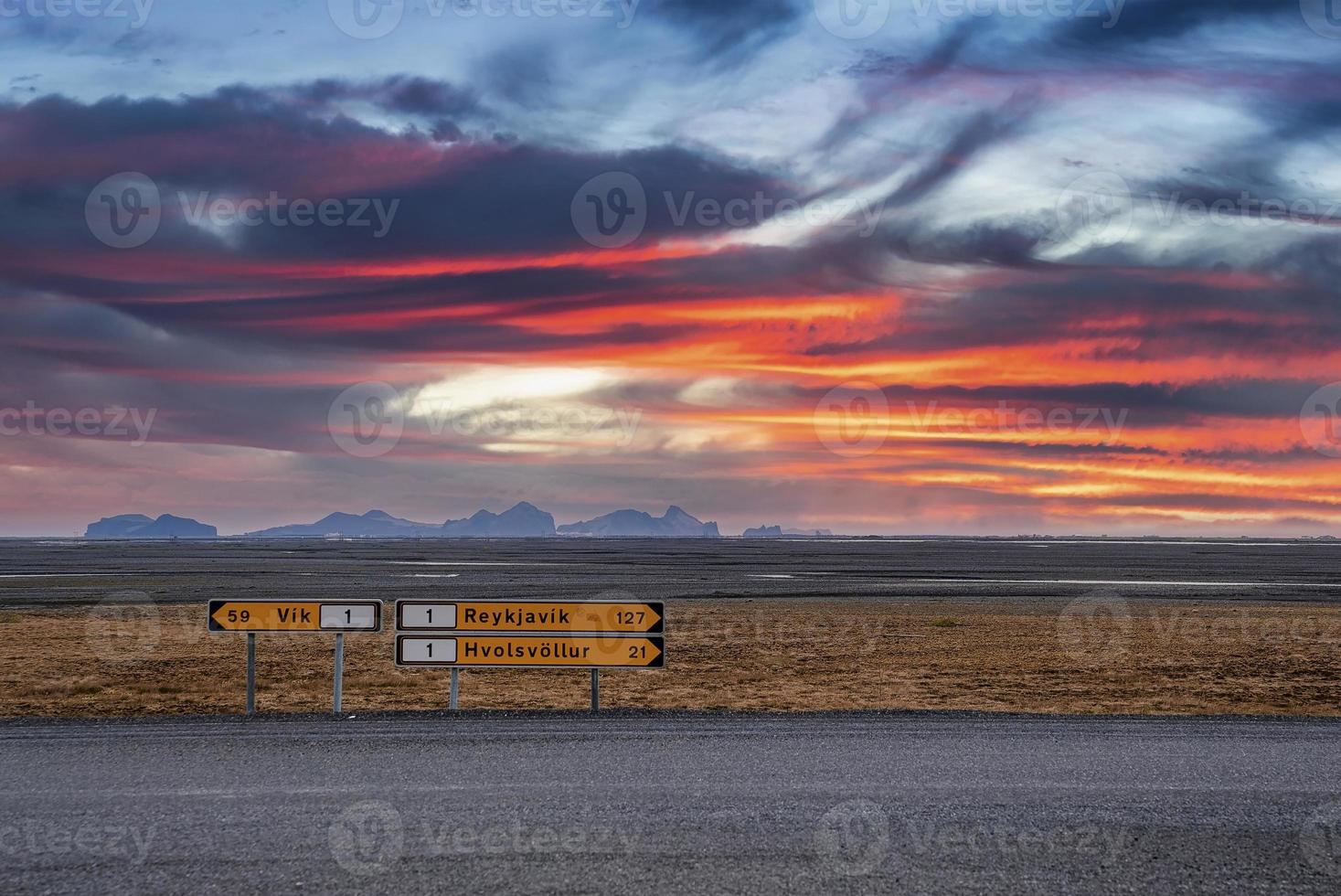 uithangborden over de weg op vulkanisch landschap tegen dramatische hemel tijdens zonsondergang foto