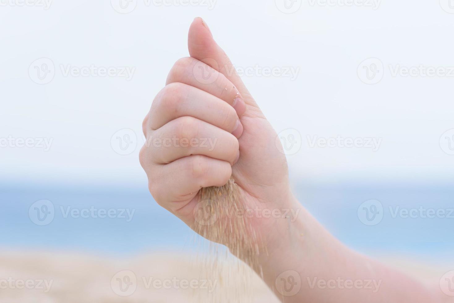 hand met zand op het strand foto